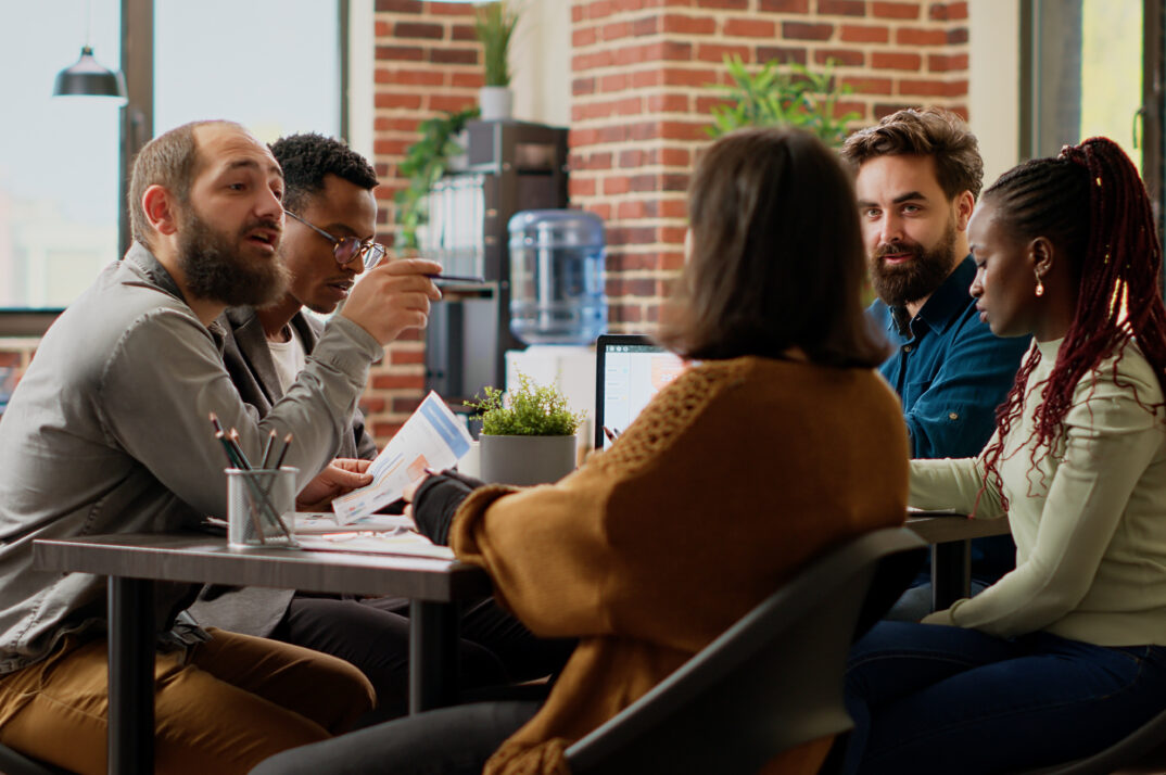 A diverse group of coworkers planning a startup project in boardroom.